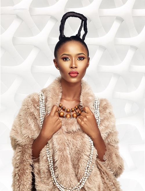 Free Portrait of an African woman in elaborate hairstyle, wearing a fur coat and beautiful jewelry. Stock Photo