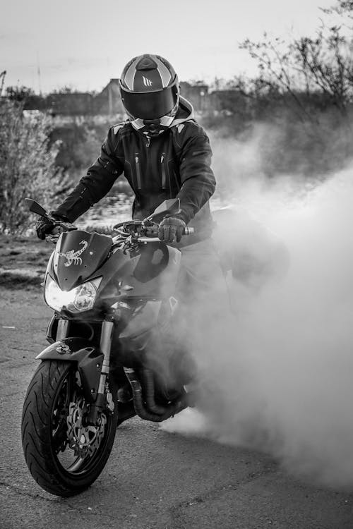 Free A Grayscale Photo of a Person Riding a Motorcycle Stock Photo