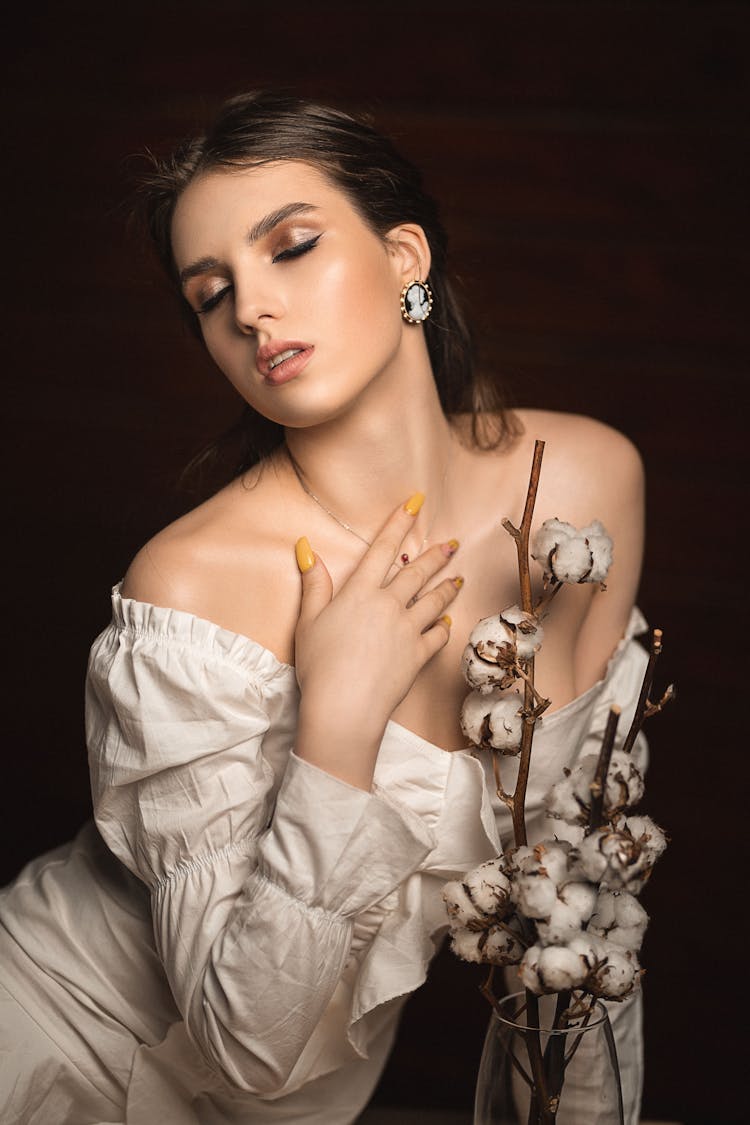 Sensual Woman In White Dress Sitting With Closed Eyes