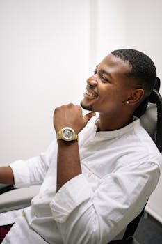 Smiling businessman relaxing in an office chair, exuding confidence and success.