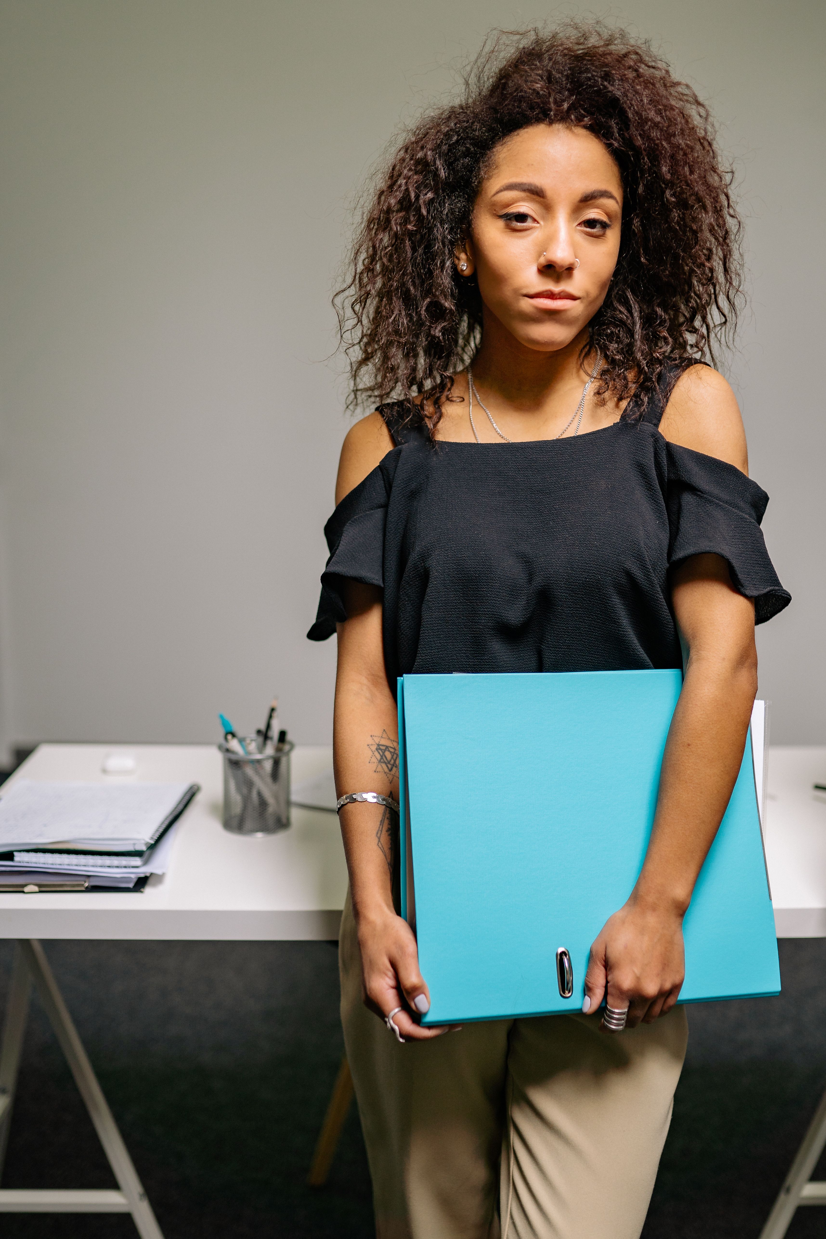 A Woman in Black Blouse Holding Blue Folder · Free Stock Photo