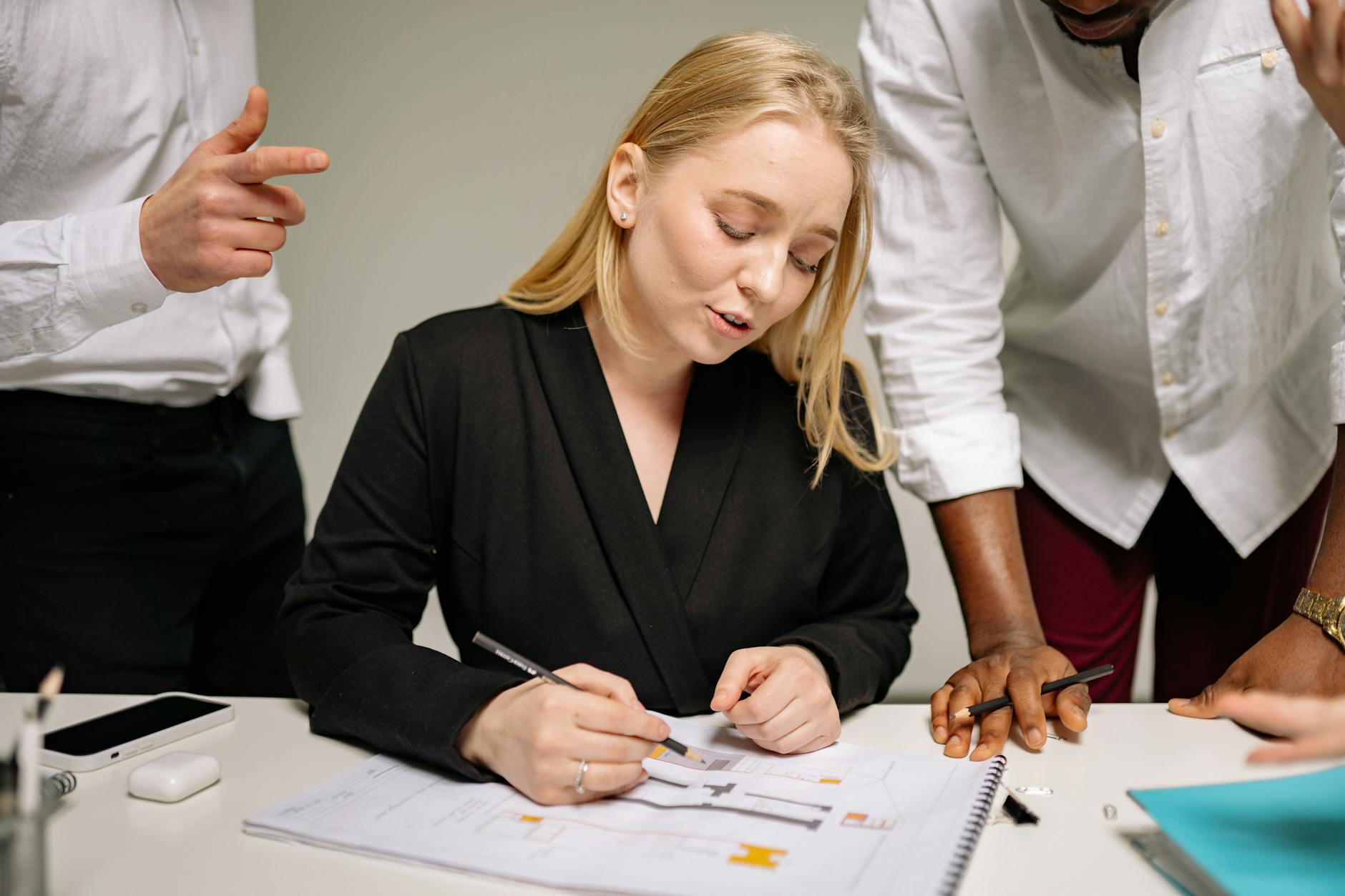 Two coworkers practicing active listening and discussing notes in a meeting, focusing on micro skills for clear communication