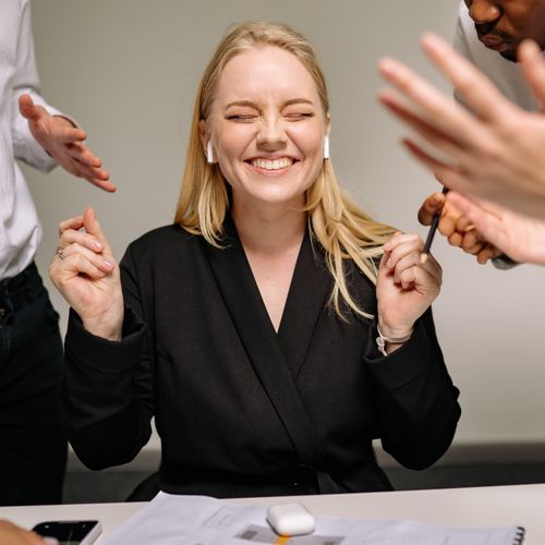 Femme souriante sollicitée de toutes parts en réunion — des journées bien remplies