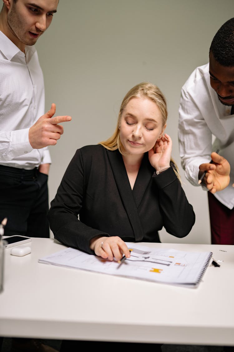 A Woman In Black Blazer Annoyed By Men Standing Beside Her