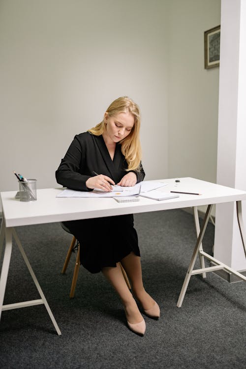 Blond Woman Writing on a Paper