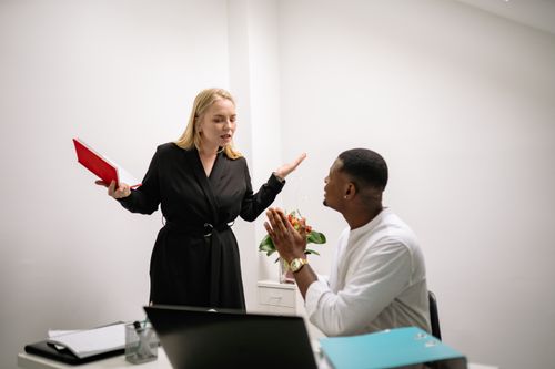 Free Colleagues in an animated discussion in an office setting, highlighting workplace communication. Stock Photo