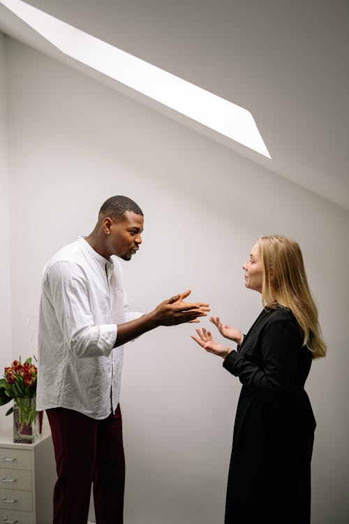 Free A serious discussion between two colleagues in an office setting, highlighting workplace conflict. Stock Photo Free A serious discussion between two colleagues in an office setting, highlighting workplace conflict. Stock Photo