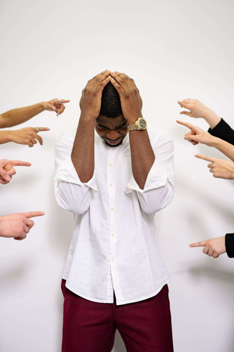 People Pointing Fingers At A Stressed Man