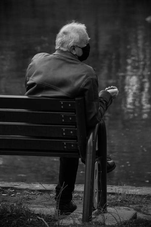 Monochrome Photo of an Elderly Man Sitting on a Bench