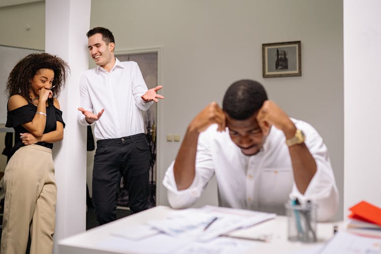 A Man And Woman Bullying Their Colleague