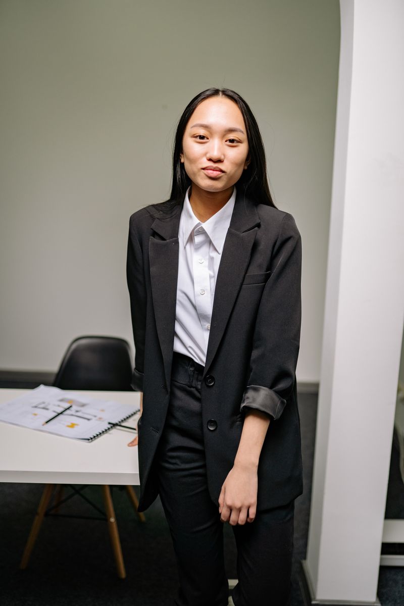 Woman in black blazer over satin slip dress
