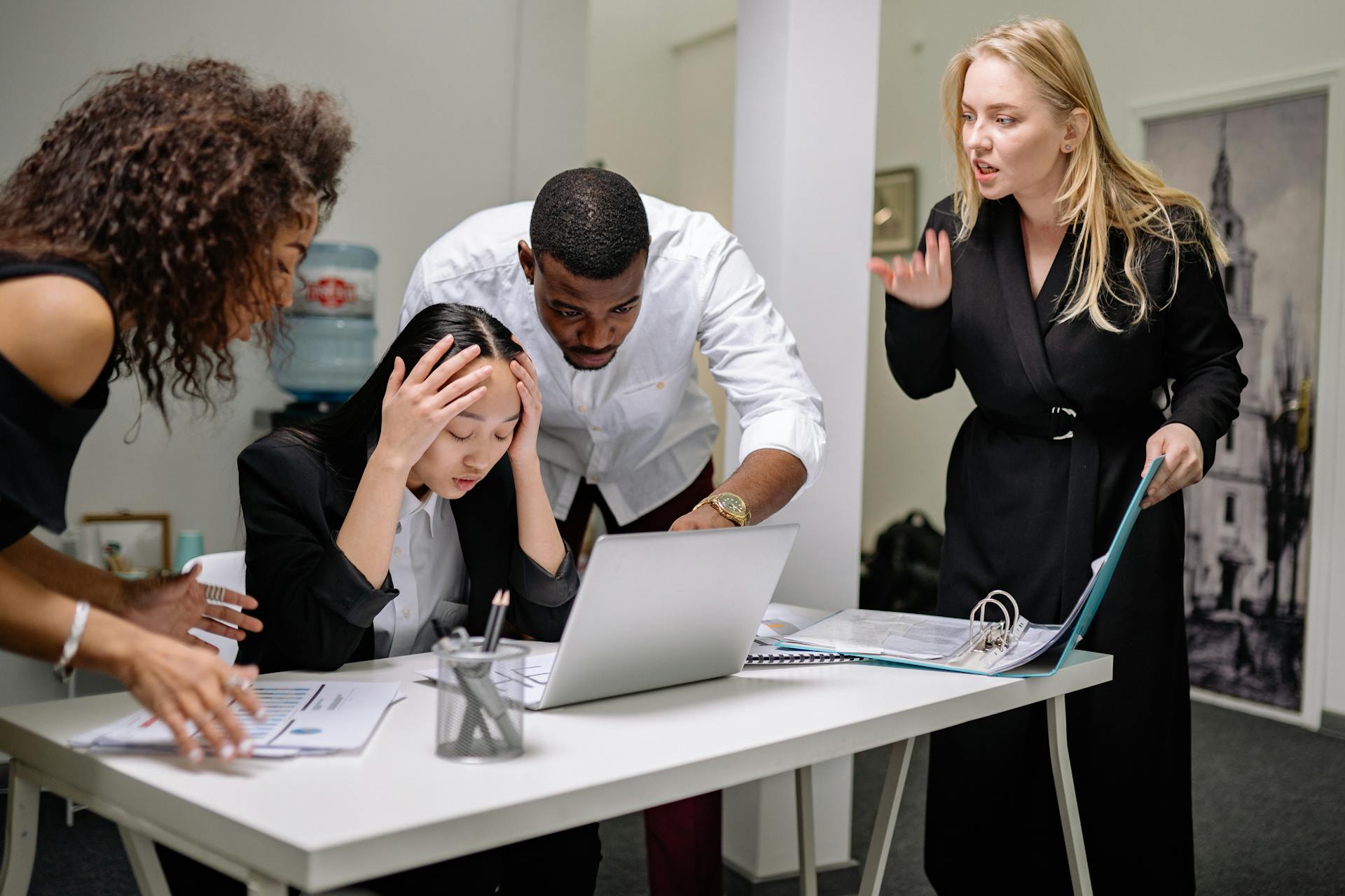 A Group of People Scolding a Woman Sitting at a Table