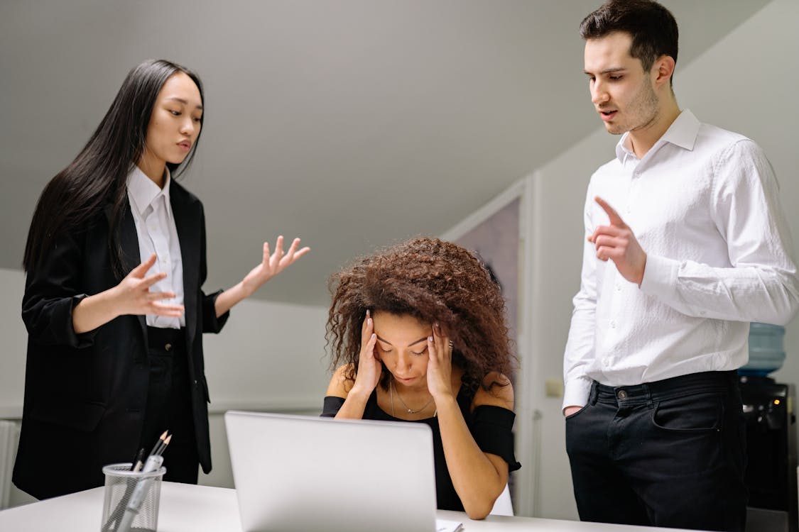 a lady holding her hand with her colleagues around her