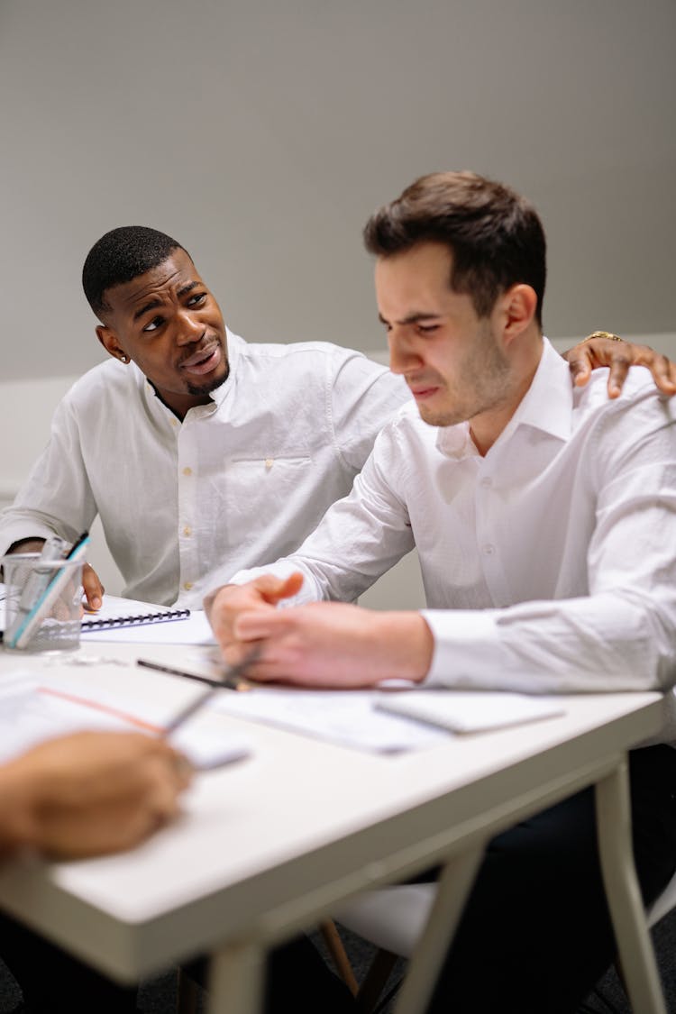 A Man In White Dress Shirt Consoling A Man Crying