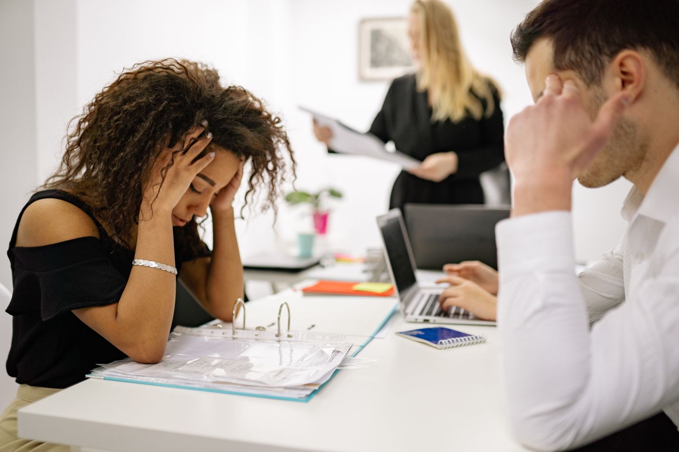 African American professional woman looking stressed while working at an office desk