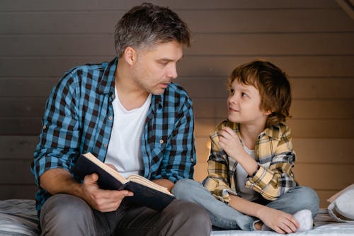 Man in Plaid Shirt Sitting Beside a Boy