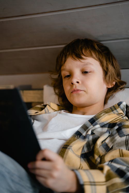 Free Boy in Plaid Shirt Holding a Tablet Stock Photo