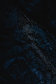 Close-up of a dark abstract textile texture with intricate patterns, perfect for backgrounds.