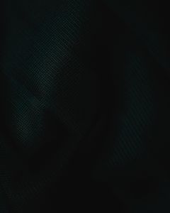 A dark fabric texture showcasing intricate patterns under subdued lighting.