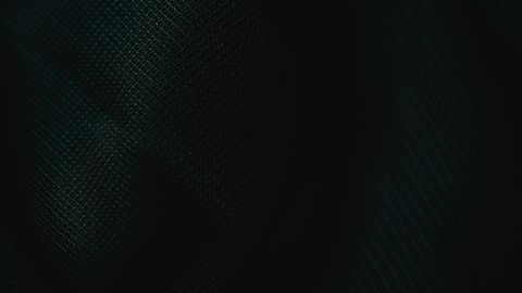 A dark fabric texture showcasing intricate patterns under subdued lighting.