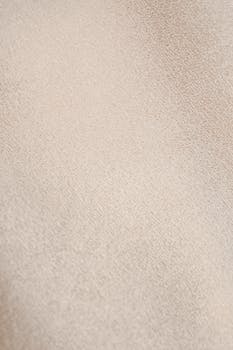 Close-up of textured beige fabric showcasing intricate patterns and textile texture.