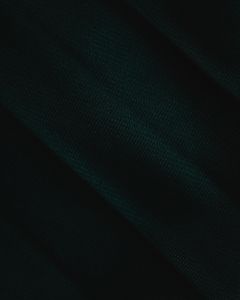 A detailed close-up of dark green fabric texture, emphasizing the material's rich color and fine detail.