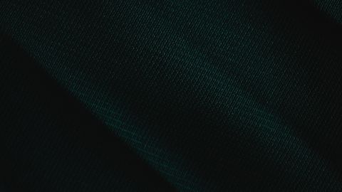 A detailed close-up of dark green fabric texture, emphasizing the material's rich color and fine detail.