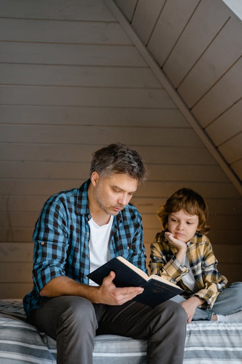 Photo of a Father Reading a Book with His Son