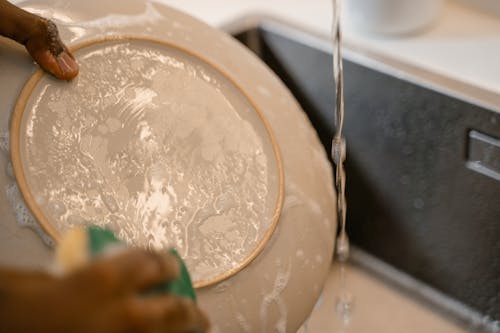 A Person Washing a Ceramic Plate