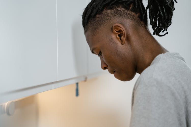 Close-up Of A Man Standing In Front Of A Cabinet