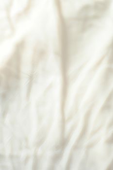 Close-up of a white fabric showcasing its texture and subtle wrinkles, ideal for textile and background use.