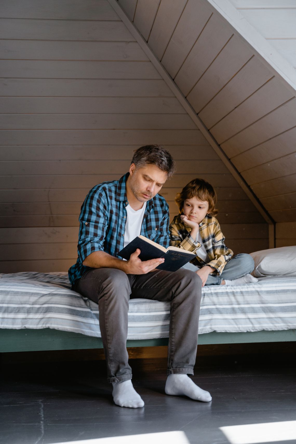 Father and son reading together in a relaxed home environment