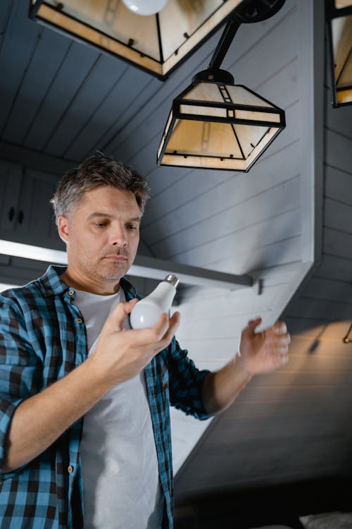 Free A Man Changing a Light Bulb Stock Photo