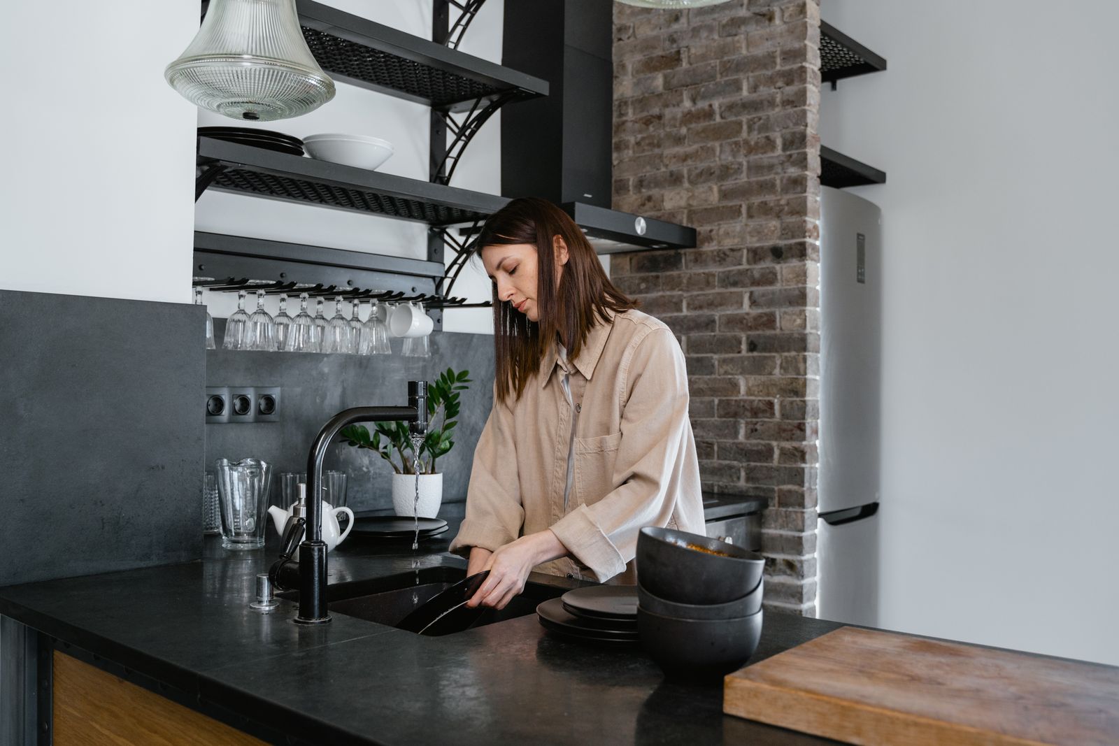 Woman washing dishes in a double bowl kitchen sink