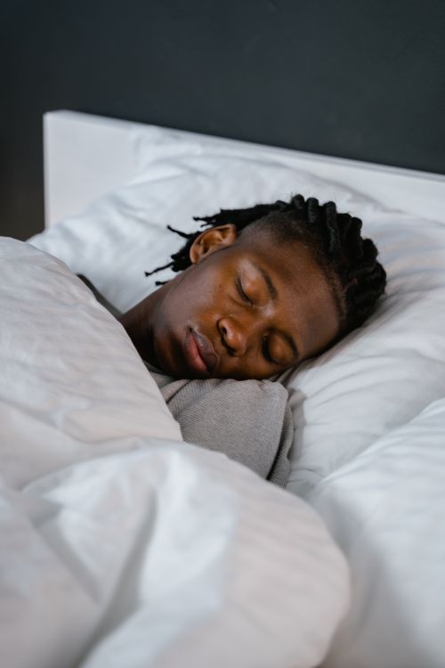 Free Young man sleeping peacefully in a cozy bed, capturing a calm and restful moment. Stock Photo