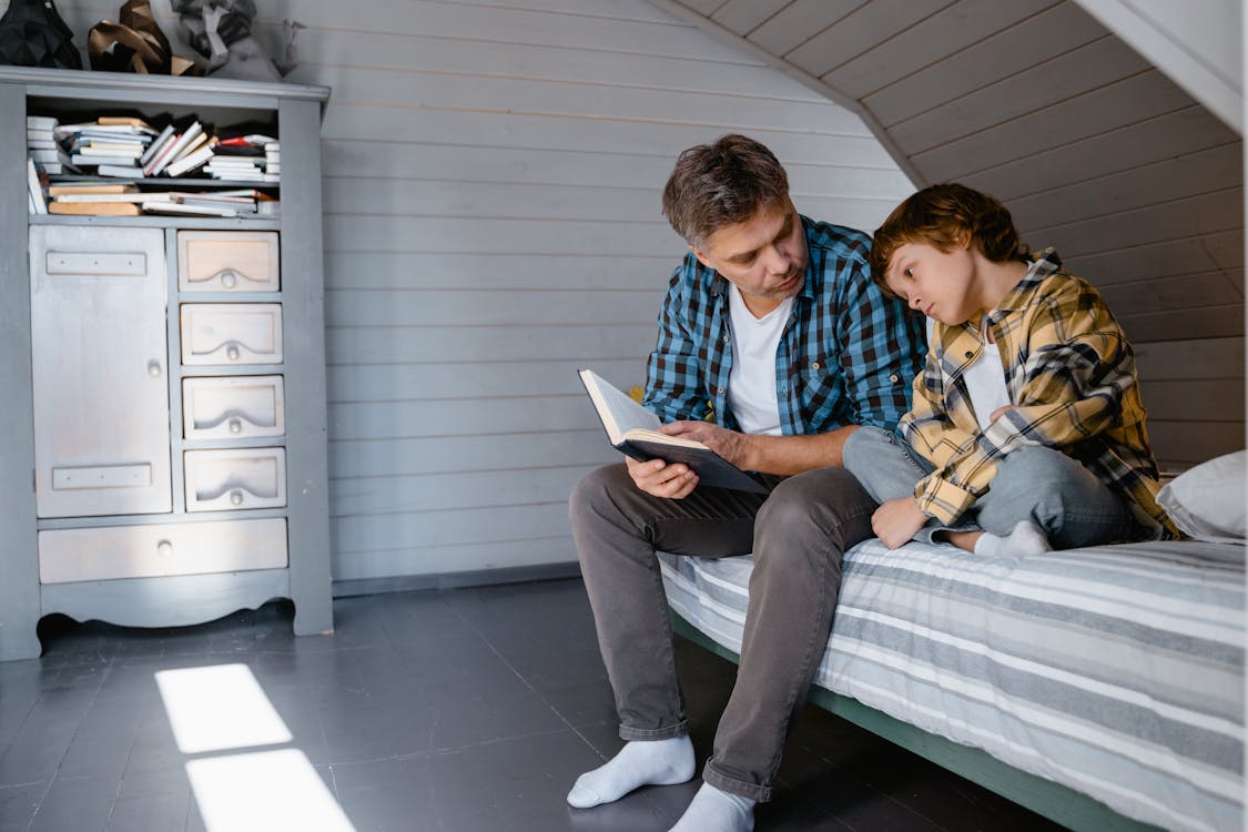 Father holding a Book looking at his Son