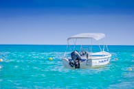 一幅宁静的画面中，一艘摩托艇停泊在碧绿平静的海面上，清澈的蓝天映衬，非常适合夏季度假