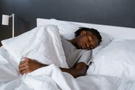 Woman in White Shirt Lying on Bed