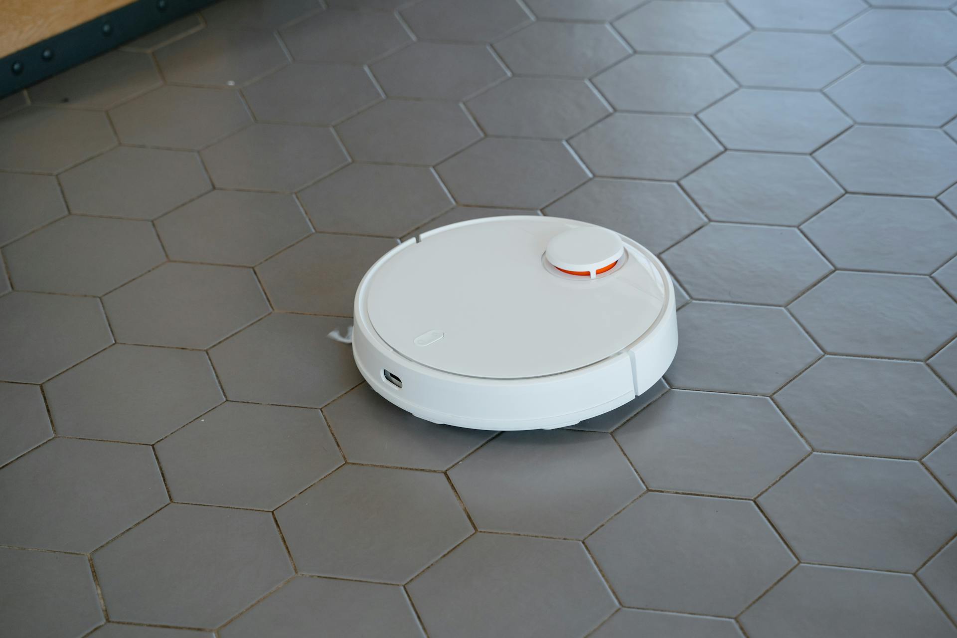 White Round Robot Vacuum on Gray Tiled Floor
