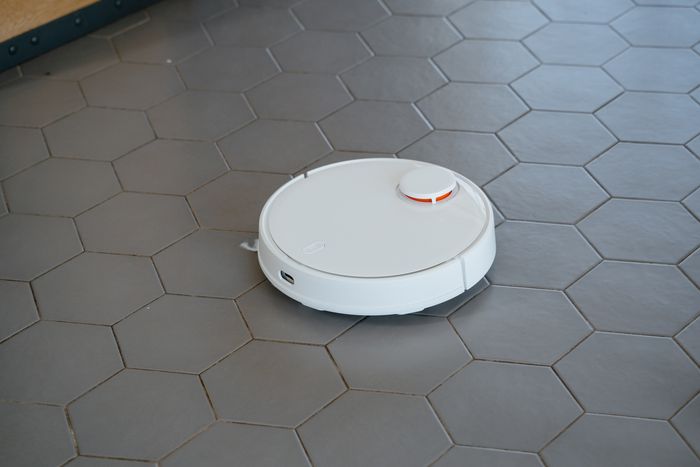 White robot vacuum cleaner on a tiled floor