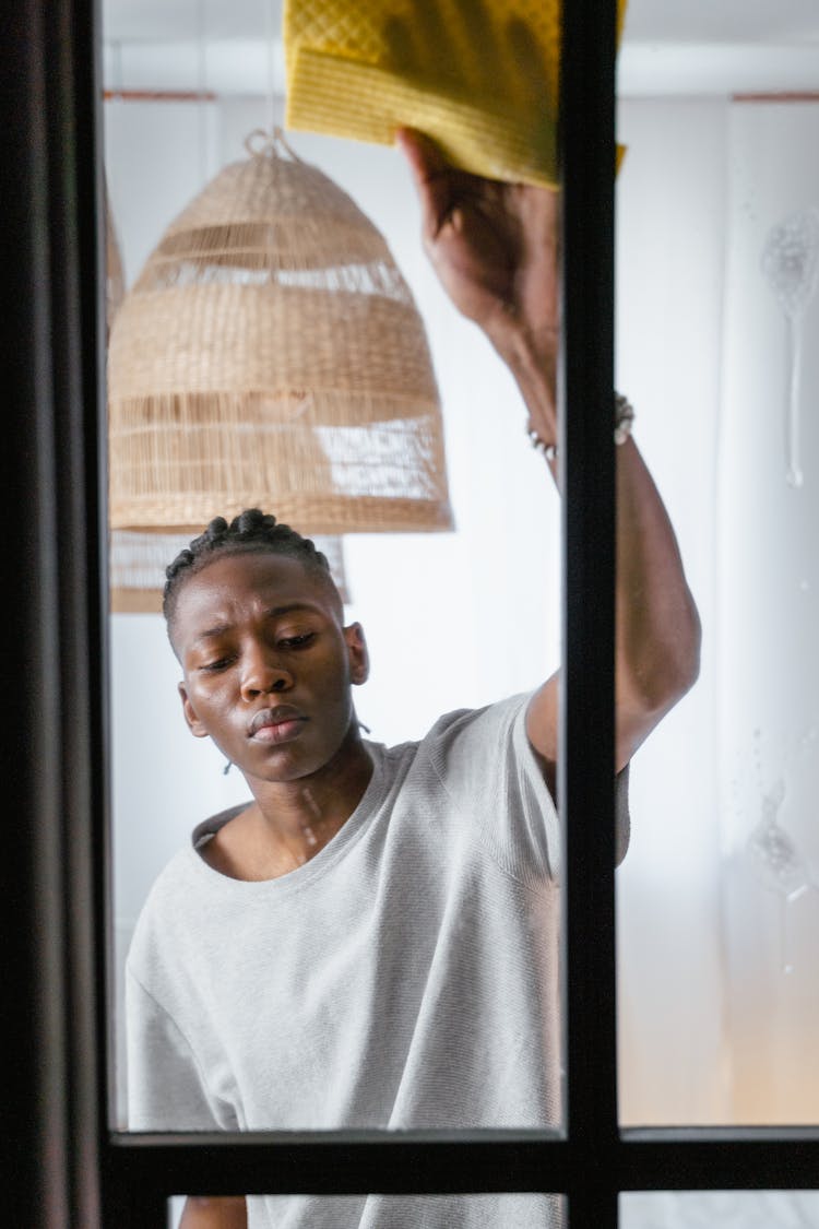 
A Man In A White Shirt Wiping A Window