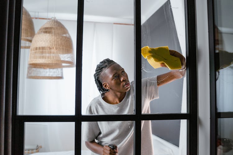 Man Cleaning Window With Yellow Rag