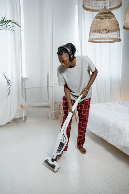 Man in Gray T-shirt Using Vacuum Cleaner