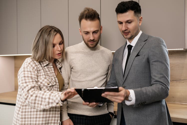 A Couple Looking At A Clipped Document