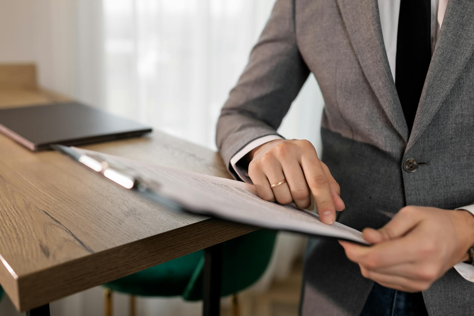 A Person in Gray Suit Holding Black Clipboard