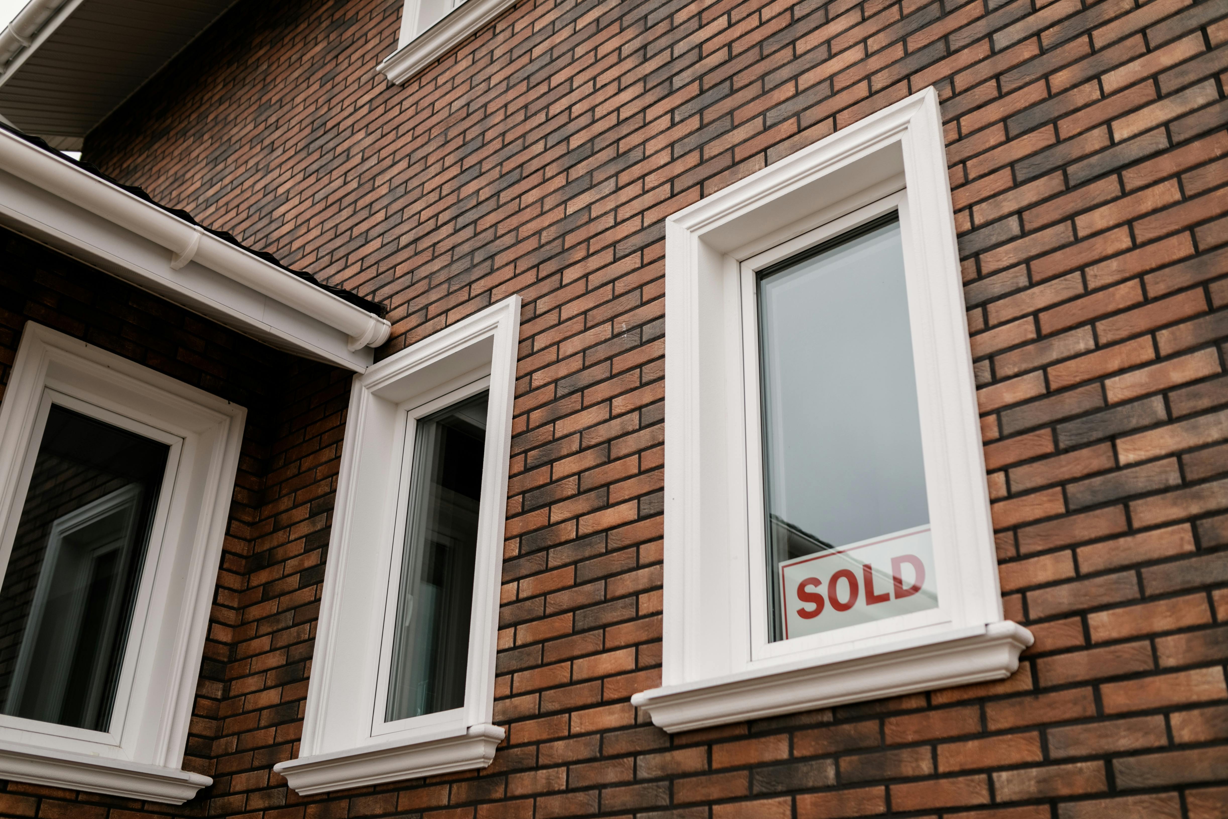 House sold sign in window of home purchased by real estate investor.