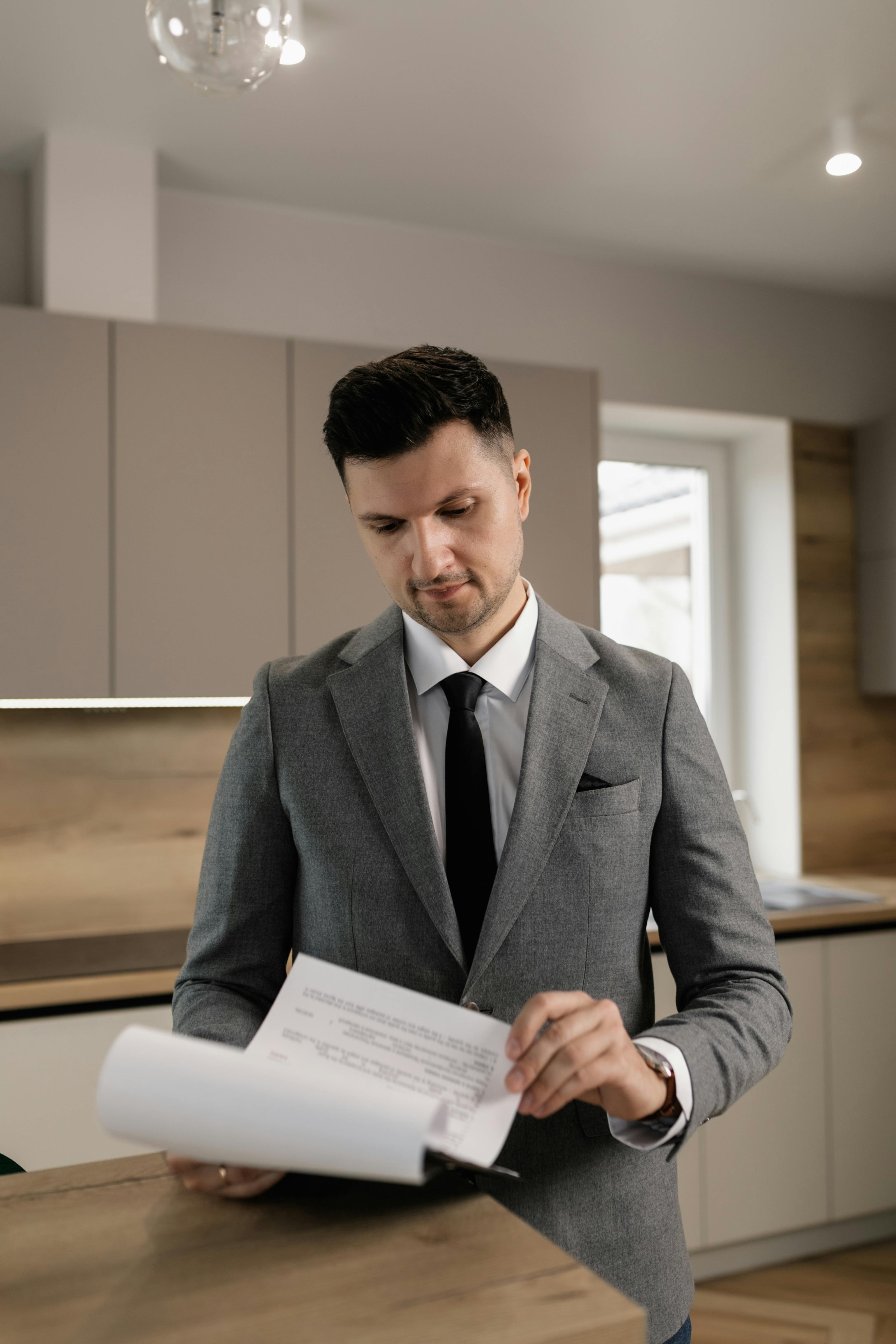 man in gray suit jacket looking at documents