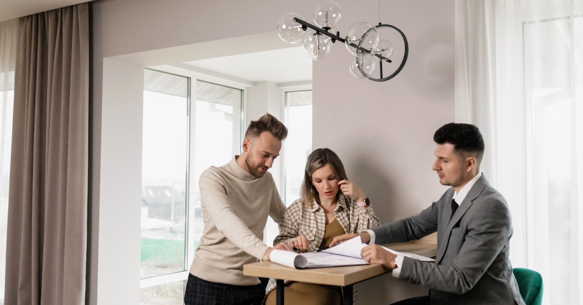 Hispanic family signing home purchase documents at a real estate office in Los Angeles