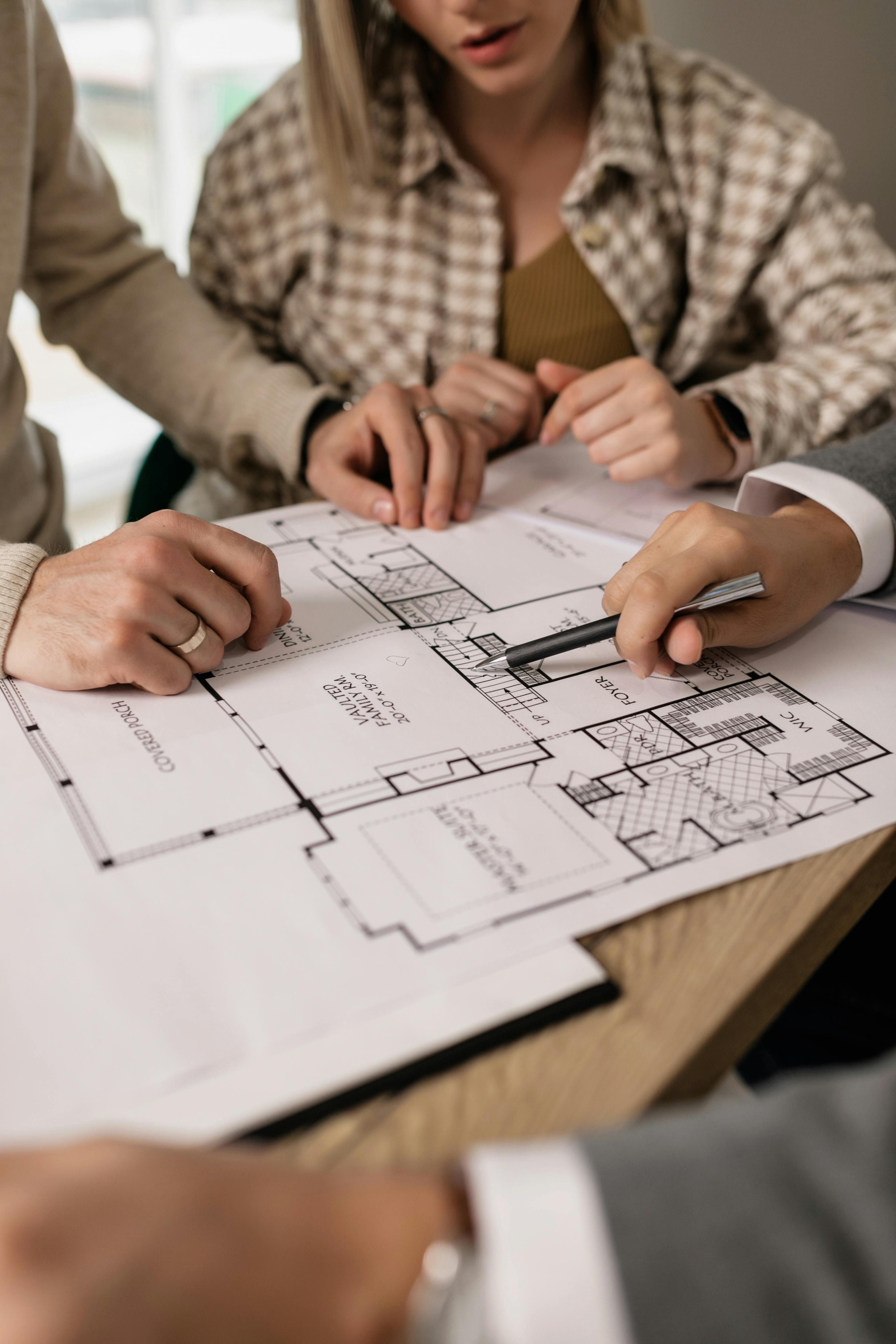 man showing a property blueprint to a couple