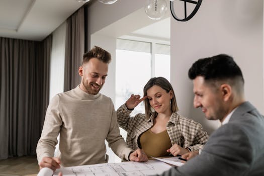 A couple consults with a real estate agent inside a cozy room, reviewing housing plans.